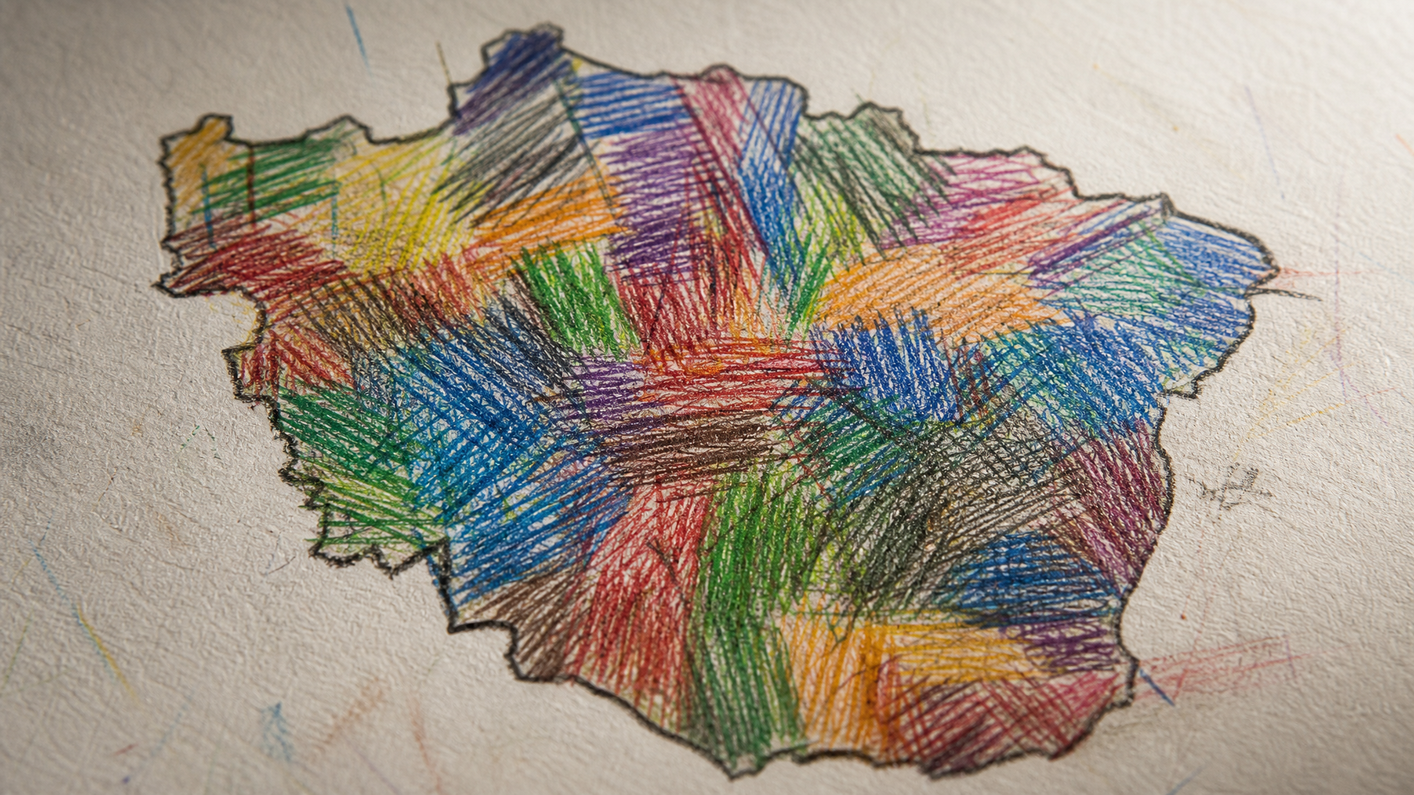 Detail view of rough colored pencil lettering pressed tightly into an irregular map-like boundary