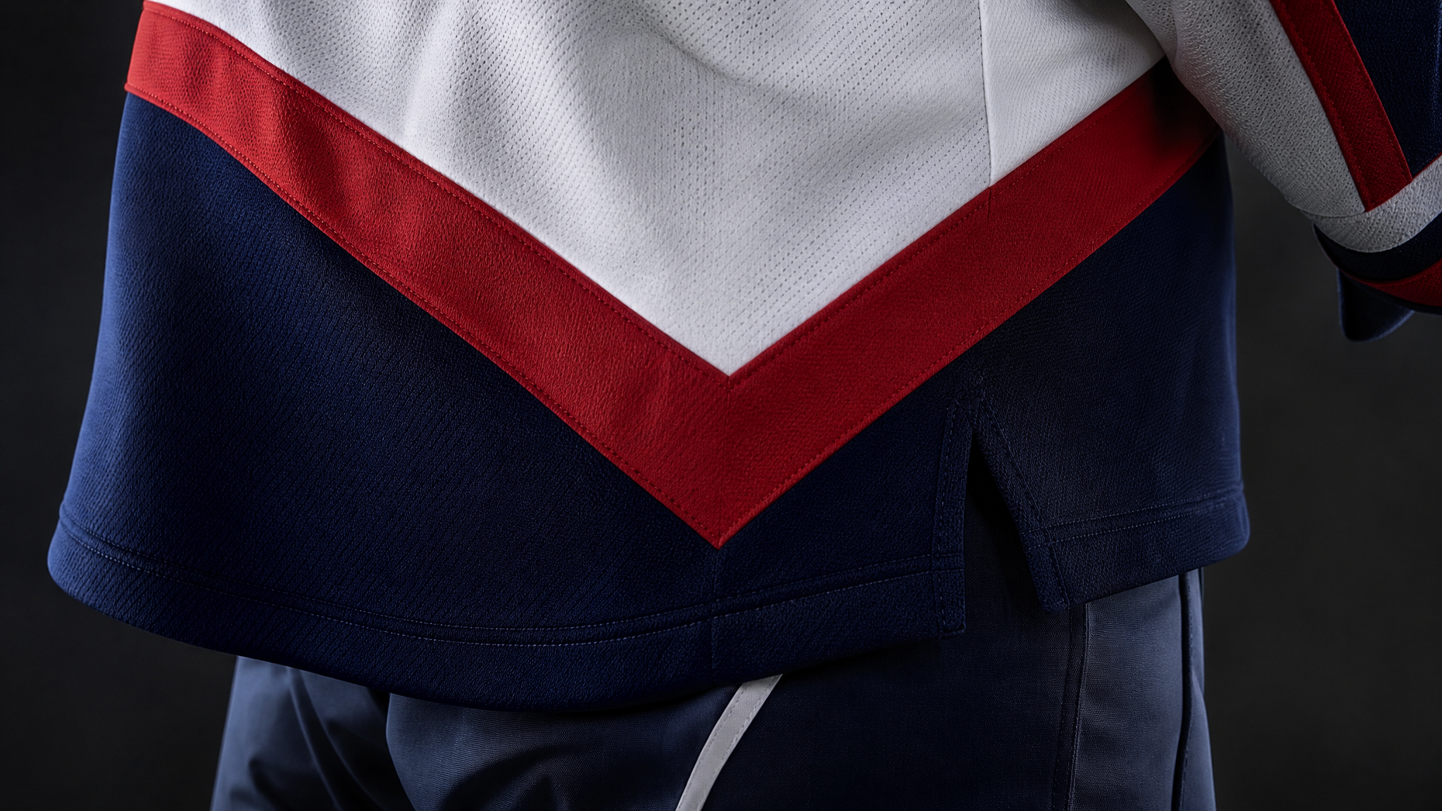 Lower side panel of a hockey jersey with sharp V-shaped color blocking